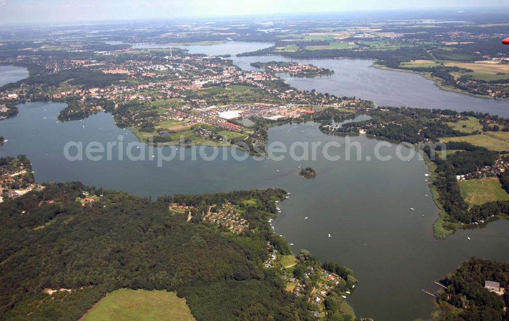 Werder (Havel) from the bird's eye view: Blick auf Werder und Umgebung. Werder ist eine Stadt westlich von Potsdam im Bundesland Brandenburg im Landkreis Potsdam-Mittelmark. Als staatlich anerkannter Erholungsort ist Werder überregional durch das jährliche Baumblütenfest im Mai bekannt, das zu den größten Volksfesten in Deutschland zählt. Die Stadt Werder wird erstmals 1317 erwähnt, die erste Besiedlung liegt bereits 10.000 Jahre zurück. Zunächst als Obststadt bekannt, ist der Weinbau nach der Fischerei das zweitälteste Gewerbe der Stadt Werder. Werder bedeutet von Wasser umgebenes Land. Werder ist vom Schwielowsee, Glindower See, Großer Plessower See und Großer Zernsee umgeben. Kontakt: Stadt Werder (Havel), Eisenbahnstr. 13-14, 14542 Werder (Havel),