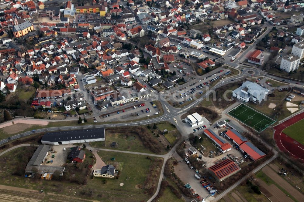 Nieder-Olm from above - View of the West of the town centre of Nieder-Olm in the state Rhineland-Palatinate. The town is located in the county district of Mainz-Bingen, in the region of Mainzer Becken. The urban area consists of wooded residential areas and single family houses and is surrounded by fields. The West of the town centre borders on the federal motorway A63 and is home to sports grounds and facilities