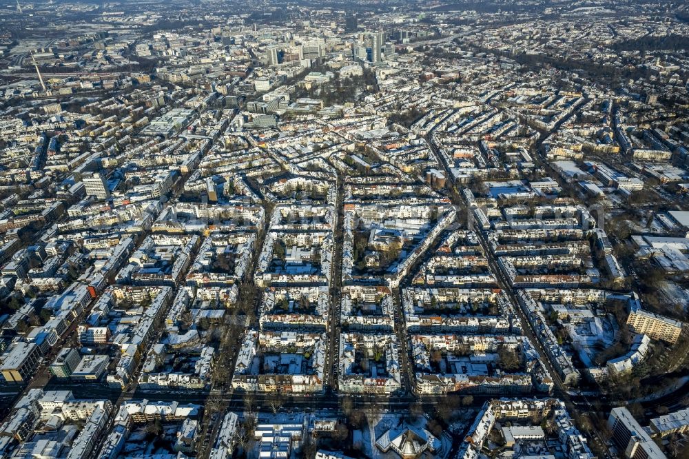 Essen from above - Cityscape of the winterly and snow-covered Ruettenscheid part of Essen in the state of North Rhine-Westphalia. The district is located in the South of downtown Essen and is home to several symmetrical, almost rectangular, apartment blocks. It is also home to several public institutions and buildings such as the police headquarters, court buildings, a prison and a clinic for forensic psychiatry