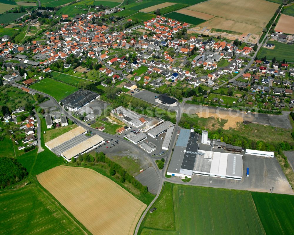 Aerial image Queckborn - Urban area with outskirts and inner city area on the edge of agricultural fields and arable land in Queckborn in the state Hesse, Germany