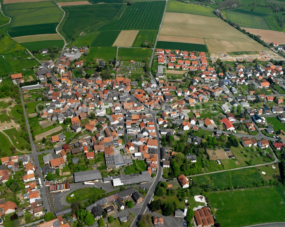 Queckborn from above - Urban area with outskirts and inner city area on the edge of agricultural fields and arable land in Queckborn in the state Hesse, Germany