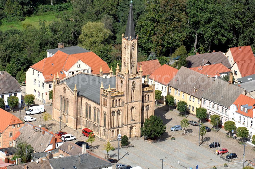 Fürstenberg/ Havel from the bird's eye view: Die Stadtkirche auf dem Marktplatz. Die heutige 50 m hohe Stadtkirche wurde 1845-48 im neubyzantinischen Stil, aus gelbem Backstein, nach Plänen von Oberbaurat Buttel, einem Schüler Schinkels, erbaut. Mit dem Bau sollte das Stadtbild verändert werden und ein attraktiver Platz in der Stadt entstehen. Um das zu erreichen, ließen die Stadtväter die Kirche in falscher Ost-West Ausrichtung bauen. Adresse der Touristeninformation: Touristinformation des Tourismusverein Fürstenberger Seenland e.V., Markt 5, 16798 Fürstenberg/Havel; Tel.: 033093/ 32254