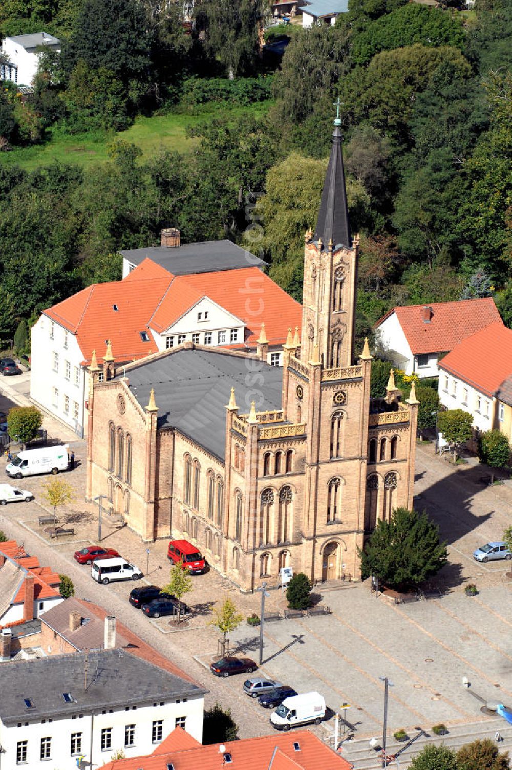 Aerial image Fürstenberg/ Havel - Die Stadtkirche auf dem Marktplatz. Die heutige 50 m hohe Stadtkirche wurde 1845-48 im neubyzantinischen Stil, aus gelbem Backstein, nach Plänen von Oberbaurat Buttel, einem Schüler Schinkels, erbaut. Mit dem Bau sollte das Stadtbild verändert werden und ein attraktiver Platz in der Stadt entstehen. Um das zu erreichen, ließen die Stadtväter die Kirche in falscher Ost-West Ausrichtung bauen. Adresse der Touristeninformation: Touristinformation des Tourismusverein Fürstenberger Seenland e.V., Markt 5, 16798 Fürstenberg/Havel; Tel.: 033093/ 32254