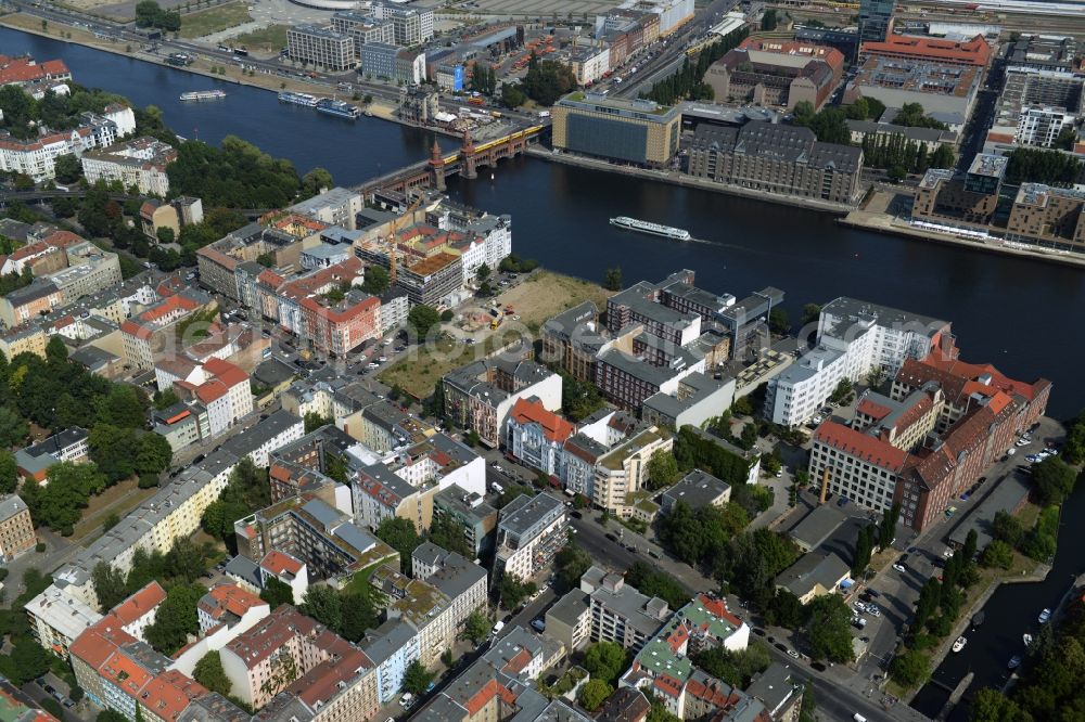 Aerial image Berlin - View of the area around Oberbaumbruecke and course of the river Spree in the district of Friedrichshain-Kreuzberg in Berlin. Several historic and modern business and office buildings as well as apartment buildings are located around the riverbank