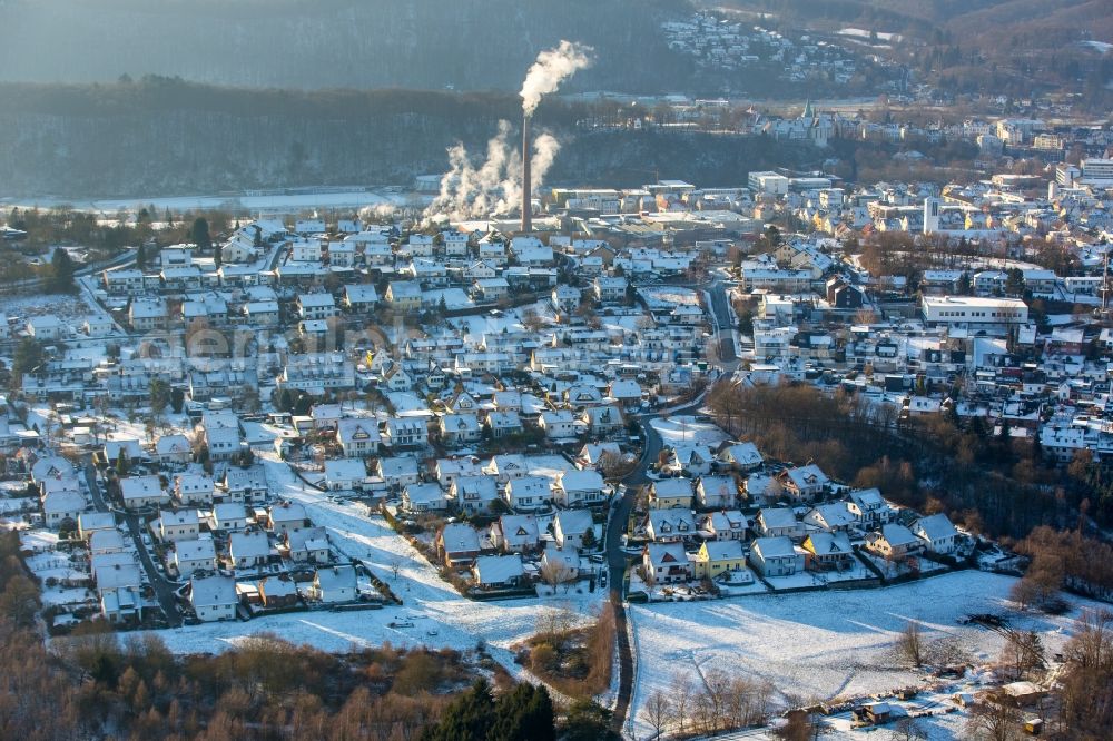 Aerial photograph Arnsberg - View of the snow covered South of Arnsberg in the state of North Rhine-Westphalia. A newly developed residential area is located in the South of the town. The background shows the factory of Reno De Medici