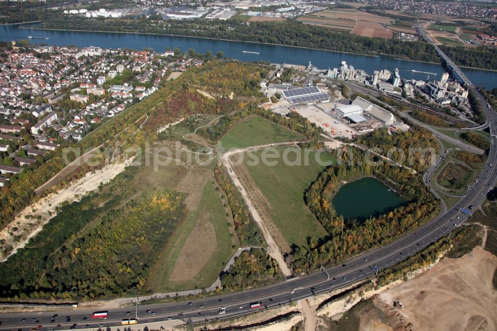 Mainz from the bird's eye view: View of the Weisenau part of Mainz in the state of Rhineland-Palatinate. The district consists of a historic centre with old residential and business buildings as well as estates and appartment blocks. It is located on the riverbank of the Rhine and partly green and wooded. The federal motorway A60 takes its course in the South of Weisenau, the cement works Mainz are located in the East