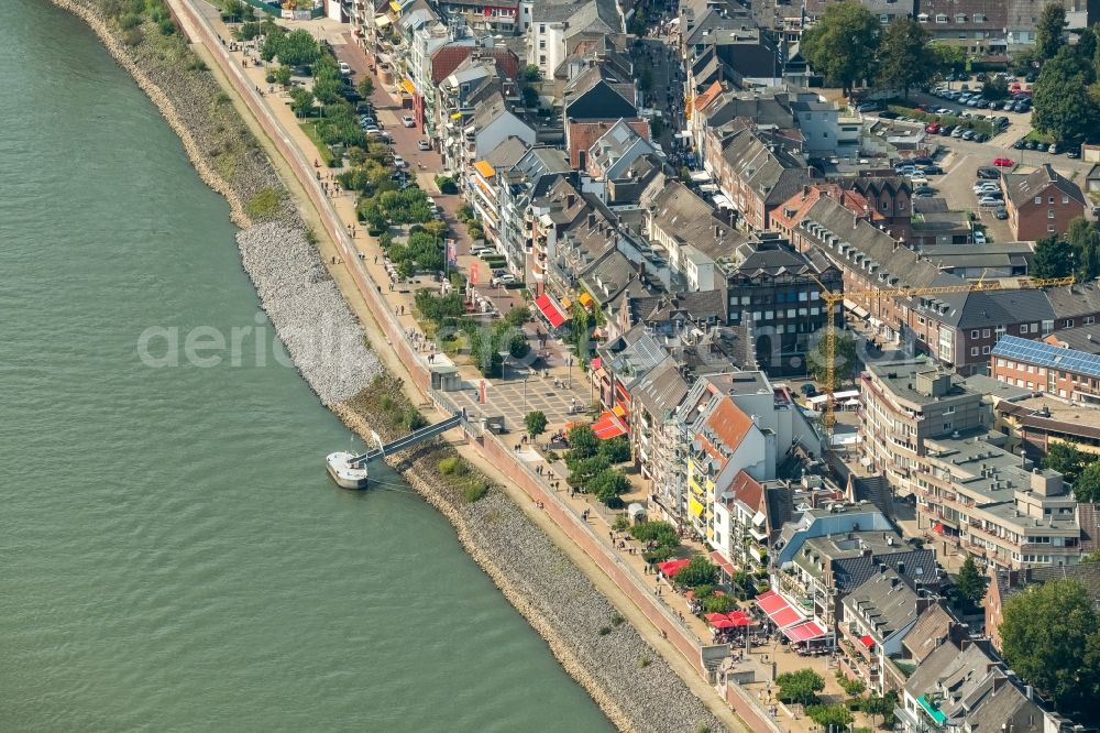 Aerial photograph Emmerich am Rhein - City center in the inner city area on the banks of river course of the Rhine river with a view of the Rheinpromenade and a construction site for the construction of a multi-family house with properties of the Rheinblick Immobilien GmbH in Emmerich am Rhein in the state of North Rhine-Westphalia, Germany