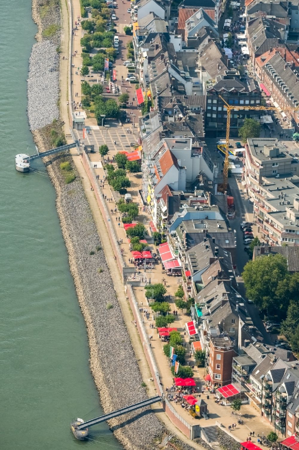 Emmerich am Rhein from above - City center in the inner city area on the banks of river course of the Rhine river with a view of the Rheinpromenade and a construction site for the construction of a multi-family house with properties of the Rheinblick Immobilien GmbH in Emmerich am Rhein in the state of North Rhine-Westphalia, Germany