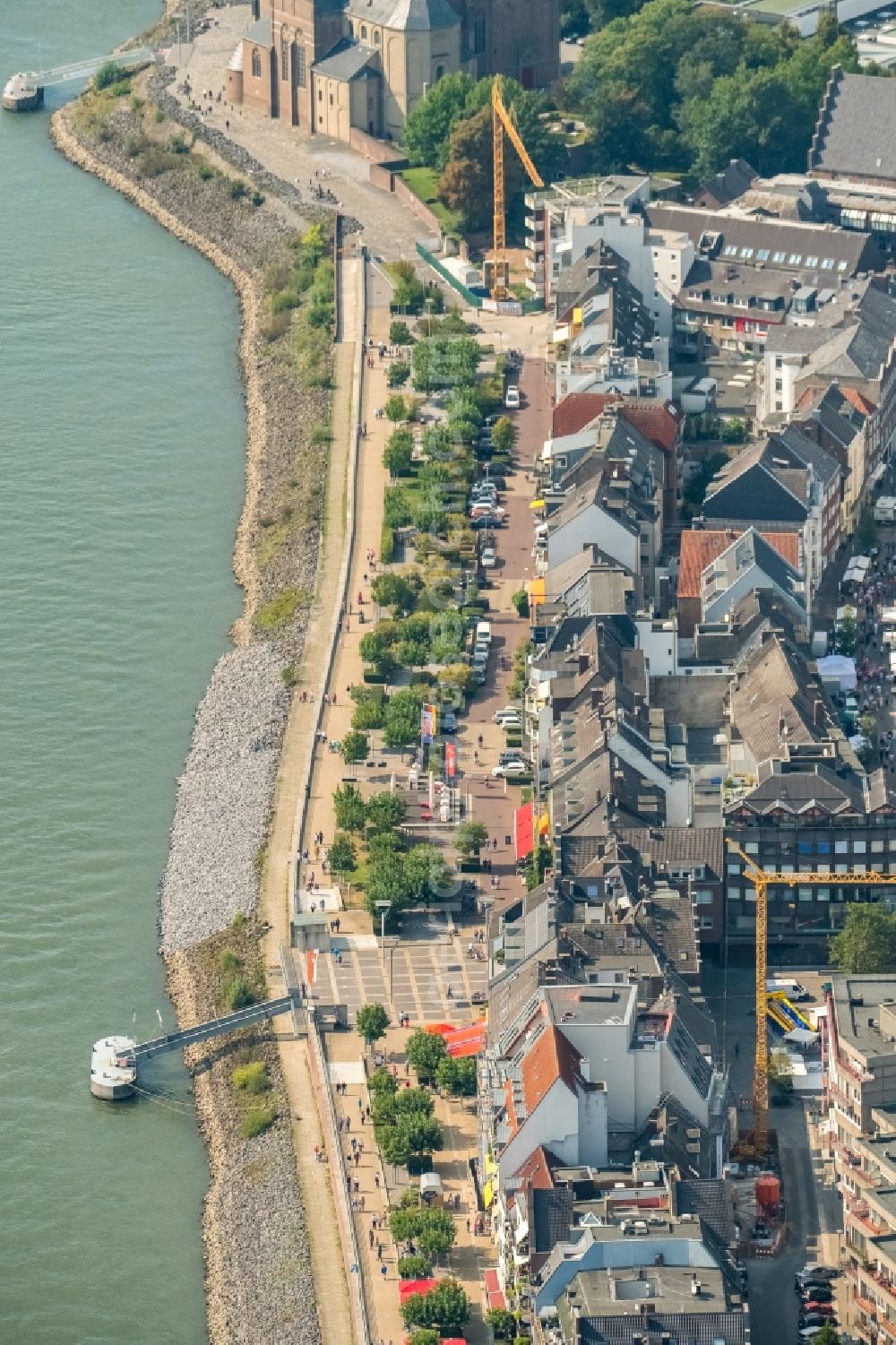 Emmerich am Rhein from the bird's eye view: City center in the inner city area on the banks of river course of the Rhine river with a view of the Rheinpromenade and a construction site for the construction of a multi-family house with properties of the Rheinblick Immobilien GmbH in Emmerich am Rhein in the state of North Rhine-Westphalia, Germany