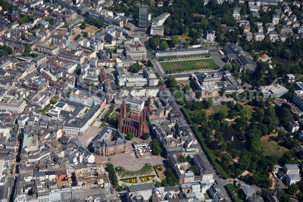 Wiesbaden from above - The market square in the city center of Wiesbaden in Hesse. The marketplace is in the foreground. Here is the red market church with its five towers, whose front is located on Palace Square opposite the City Palace. The triangular building next to the church is the town hall of Wiesbaden. On the north side of the Schlossplatz is the City Palace, which today is the Hessian Landtag. On the right side, the Hessian State Theatre is a large green area