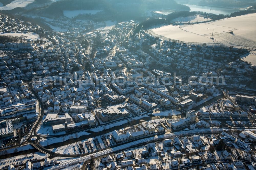 Meschede from above - Winterly snowy city view of Meschede beneath the rivers Ruhr and Henne aswell as rails of the Deutsche Bahn AG and surrounding snowy fields in the state North Rhine-Westphalia