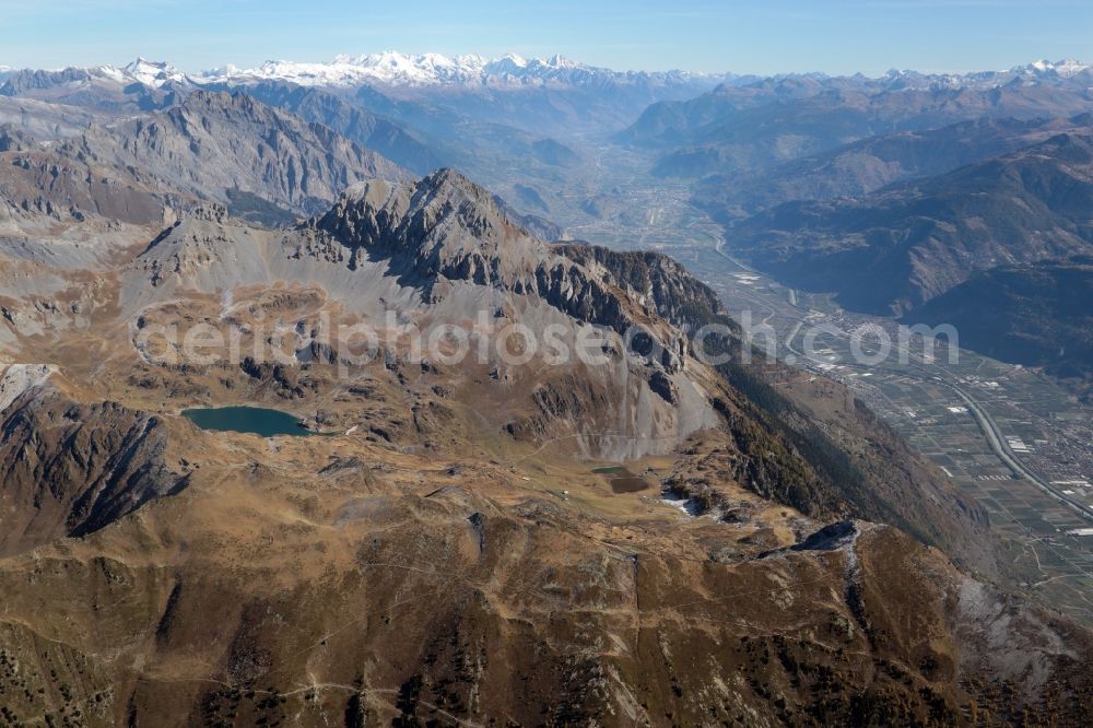 Fully from the bird's eye view: Mountainous landscape at the Lake Fully in Fully in the canton Valais, Switzerland. Looking over the Grand Chavalard mountain eastbound into the Rhone valley,