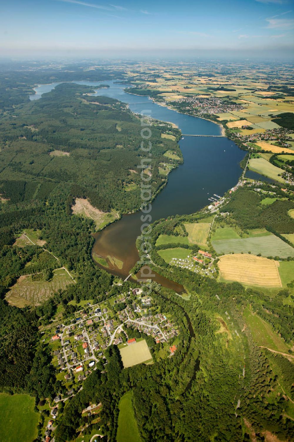 Aerial photograph Möhnesee - Blick auf den Stausee Möhnesee in Nordrhein-Westfalen. Die Möhnetalsperre dient der Niedrigwasseraufhöhung, dem Hochwasserschutz und der Stromerzeugung aus Wasserkraft. Vorrangiges Ziel ist die Niedrigwasseraufhöhung der Ruhr, in die das Wasser der Talsperre über den Unterlauf Möhne und den Zusammenfluss in Neheim (Stadt Arnsberg) gelangt. Reservoir Möhnesee in North Rhine-Westphalia.