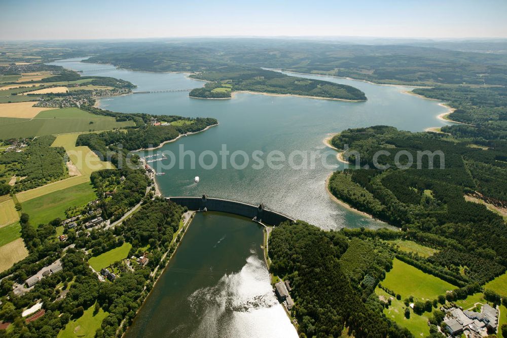 Aerial image Möhnesee - Blick auf den Stausee Möhnesee in Nordrhein-Westfalen. Die Möhnetalsperre dient der Niedrigwasseraufhöhung, dem Hochwasserschutz und der Stromerzeugung aus Wasserkraft. Vorrangiges Ziel ist die Niedrigwasseraufhöhung der Ruhr, in die das Wasser der Talsperre über den Unterlauf Möhne und den Zusammenfluss in Neheim (Stadt Arnsberg) gelangt. Reservoir Möhnesee in North Rhine-Westphalia.