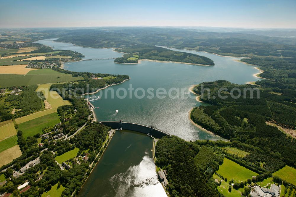 Aerial photograph Möhnesee - Blick auf den Stausee Möhnesee in Nordrhein-Westfalen. Die Möhnetalsperre dient der Niedrigwasseraufhöhung, dem Hochwasserschutz und der Stromerzeugung aus Wasserkraft. Vorrangiges Ziel ist die Niedrigwasseraufhöhung der Ruhr, in die das Wasser der Talsperre über den Unterlauf Möhne und den Zusammenfluss in Neheim (Stadt Arnsberg) gelangt. Reservoir Möhnesee in North Rhine-Westphalia.