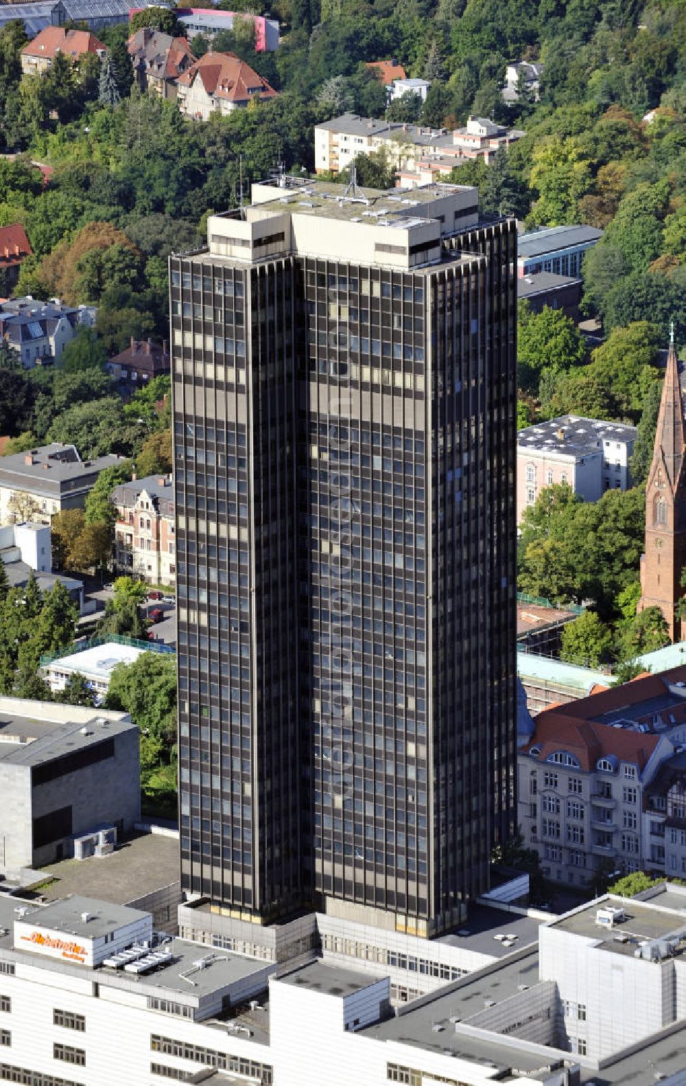 Berlin from above - Blick auf den Steglitzer Kreisel , einen Gebäudekomplex mit Bürohochhaus im Berliner Ortsteil Steglitz. 2006 hatte der Berliner Senat beschlossen, das Bürohochhaus aufzugeben und die dort beschäftigten Mitarbeiter des Bezirksamts Steglitz-Zehlendorf in an deren landeseigenen Immobilien unterzubringen. 2007 wurde das Haus geräumt und steht derzeit leer. Die Berliner Finanzverwaltung und der Liegenschaftsfonds hatten vergeblich versucht, das Gebäude im jetzigen Zustand zu verkaufen. Die weitere Nutzung ist ungeklärt, neben dem Verkauf an Wolfgang Gerbere Investoren wird auch ein Abriss nicht ausgeschlossen. View of the Steglitzer Kreisel, a complex of office tower at the Berlin district of Steglitz.