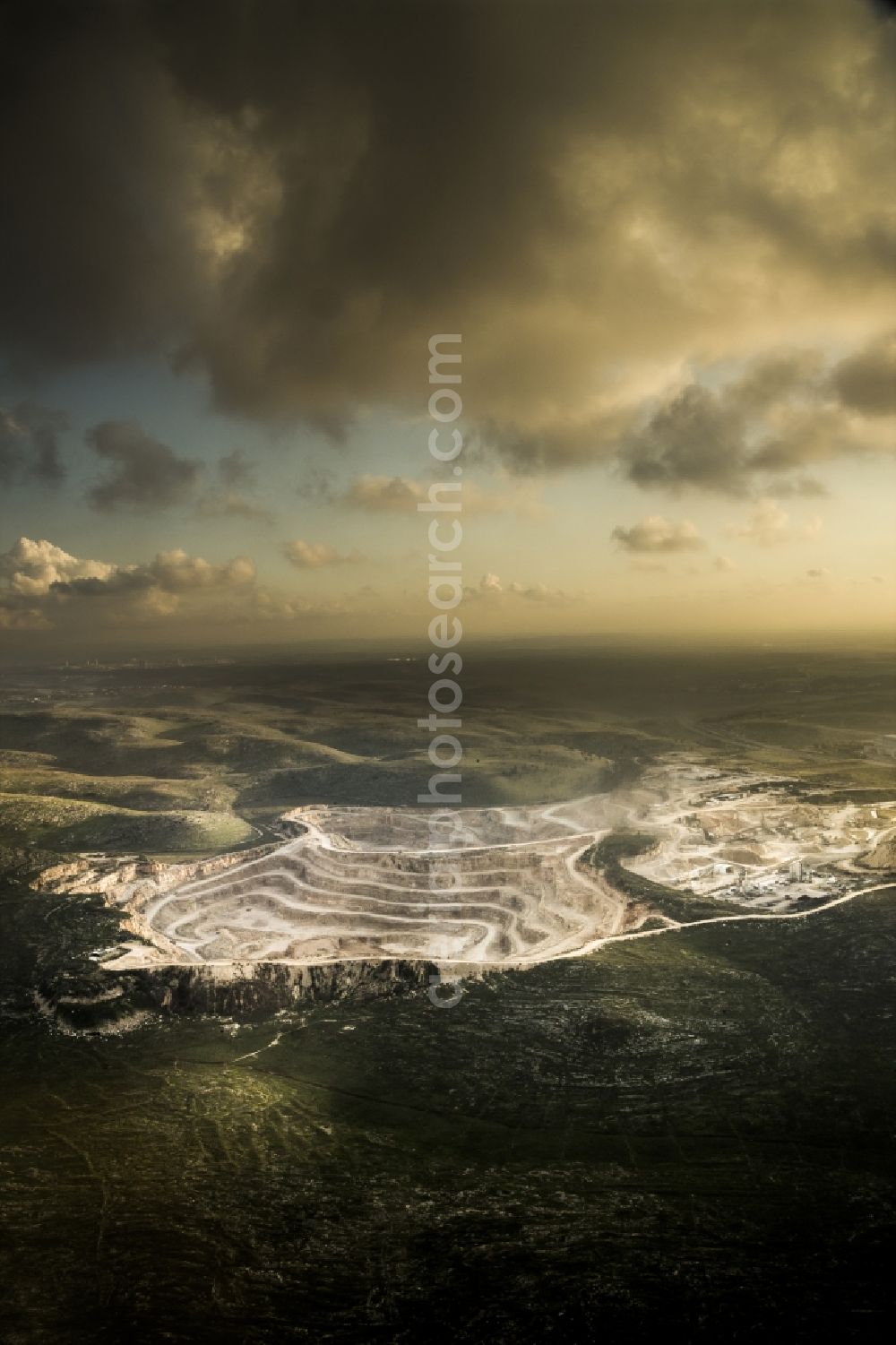 Ramla from the bird's eye view: Stone quarry pit close to the Moshav Yad Rambam in the Central District of Israel. Nearby is the district capital of Ramla. A Moshav is a settlement and particular type of cooperative agricultural community. The quarry lies between the motorways Route 1 and Route 6 approximately 35 km south east of Tel Aviv