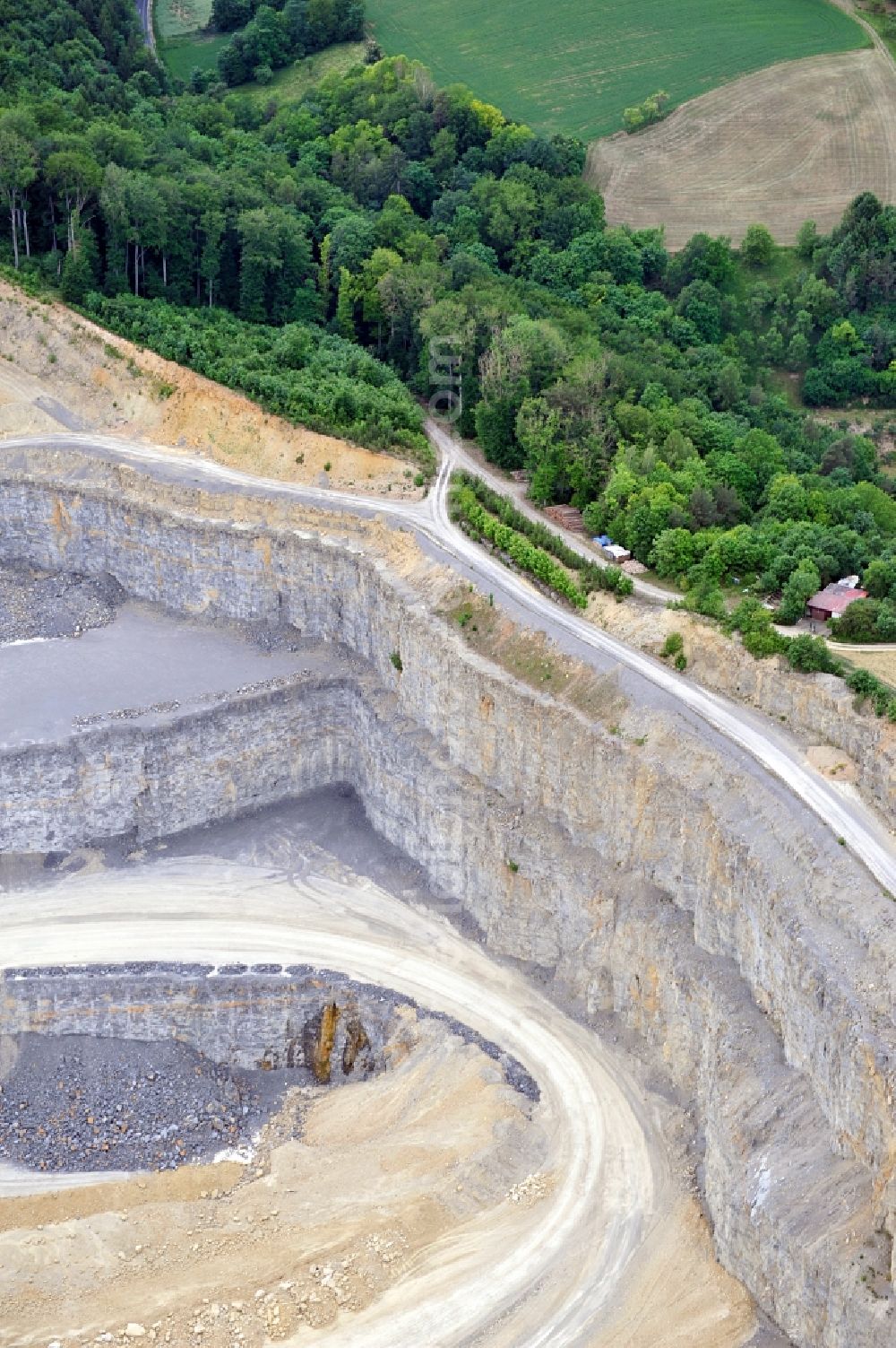 Karlstadt from the bird's eye view: Steinbruch in Karlstadt OT Mühlbach im Bundesland Bayern. Der Steinbruch liefert Material zur Zementherstellung für das gegenüberliegende Zementwerk der Firma Schwenk.