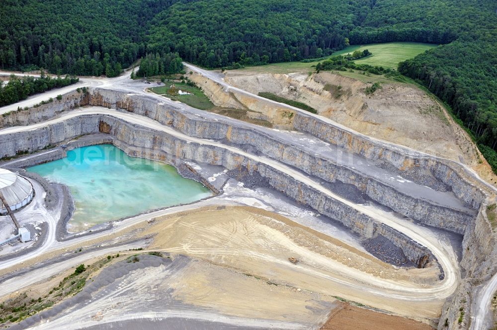 Aerial image Karlstadt - Steinbruch in Karlstadt OT Mühlbach im Bundesland Bayern. Der Steinbruch liefert Material zur Zementherstellung für das gegenüberliegende Zementwerk der Firma Schwenk.