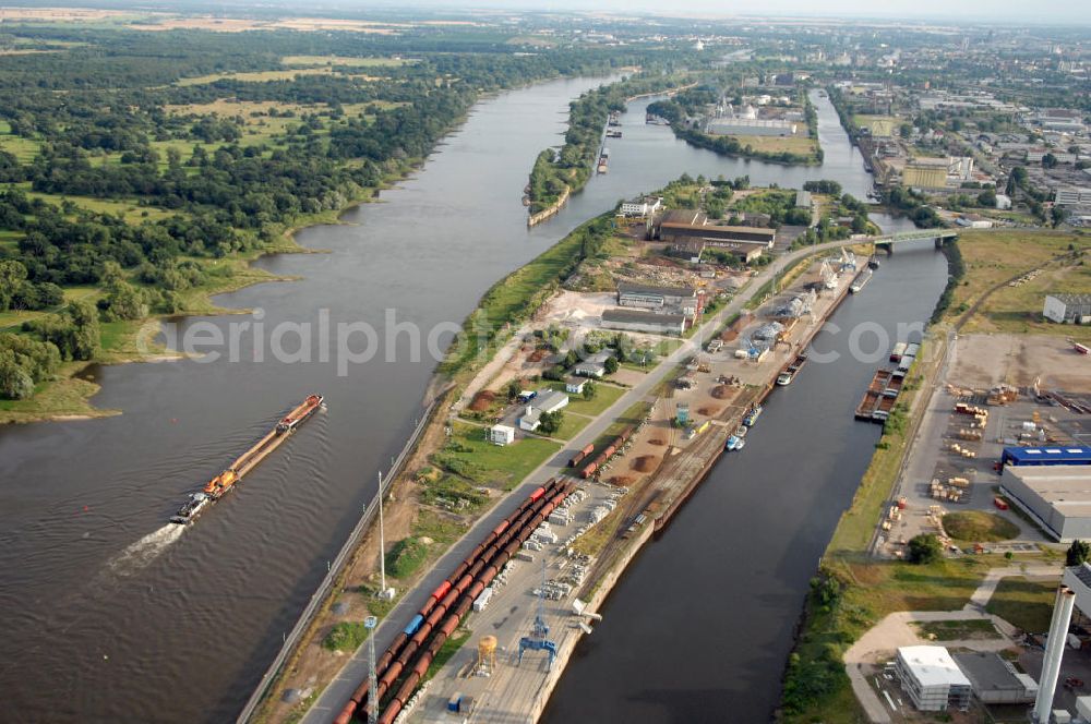 Magdeburg from the bird's eye view: Blick auf die Steinkopfinsel im Hafen Magdeburg an der Elbe. Umflossen wird die Steinkopfinsel im Osten von der Elbe und dem Abstiegskanal Rothensee, sowie im Westen vom Zweigkanal Magdeburg. Die Insel ist ca. 2,5 km lang und ca. 0,3 km breit (an der stärksten Stelle). Der Binnenhafen ist in vier Güterumschlagplätze eingeteilt, der Handelshafen, Industriehafen, Kanalhafen und der Hanseshafen. Das Gebiet verteilt sich über die Stadtteile Alte-Neustadt, Industriehafen und Gewerbegebiet Nord. Jedoch hat der Handelshafen für die Schiffahrt heute keine Bedeutung mehr, dieser Bereich wird stetig zum Wissenschaftsstandort umgebaut. Kontakt: Magdeburger Hafen GmbH, Saalestraße 20, 39126 Magdeburg, Tel. +49(0)391 5939-0, Fax +49(0)391 5616648, email: Logistik@magdeburg-hafen.de