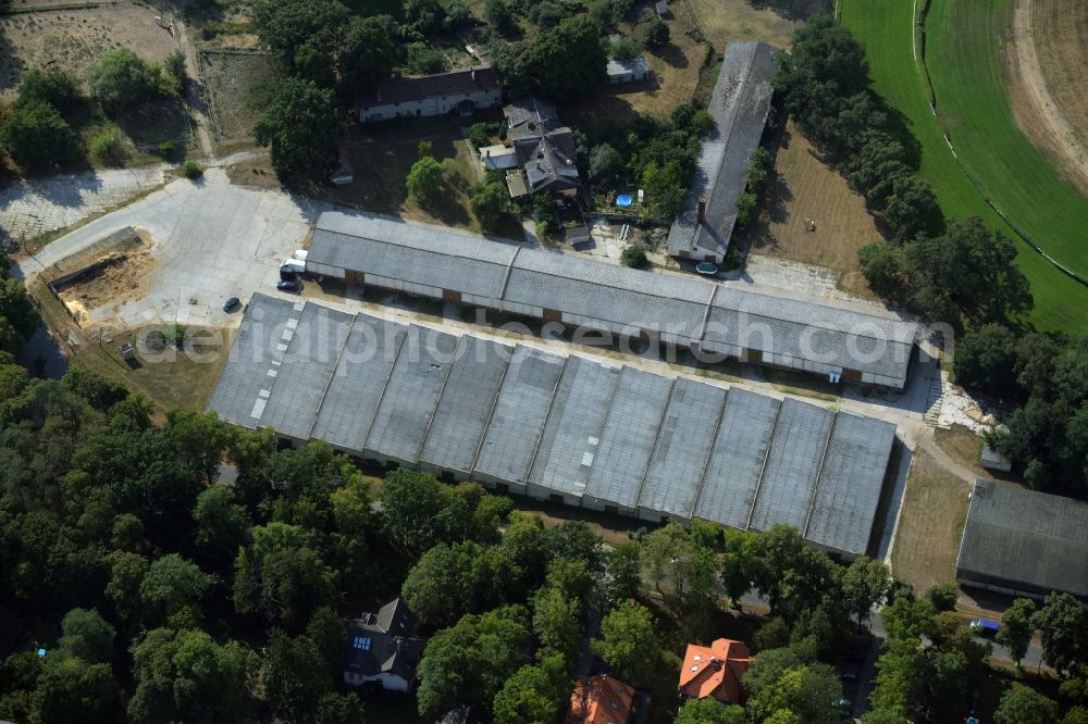 Aerial photograph Hoppegarten - Building of stables and outbuildings of the horse race track in Hoppegarten in the state of Brandenburg. The buildings and storage halls are located on the Northern end of the historic race track