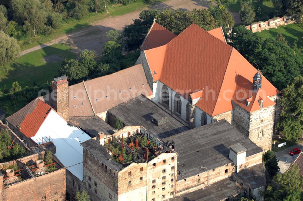 Nienburg from above - Strasse der Romanik: Von der Bedeutung des Ortes Nienburg, 5 km nördlich von Bernburg an der Mündung der Bode in die Saale gelegen, zeugt der heute noch eindrucksvolle Bau der Benediktiner-Klosterkirche St. Marien und St.Cyprian auf einer felsigen Anhöhe über dem linken Ufer der Bode. Zu erkennen ist auch das Ruinengebäude der alten Malzfabrik.