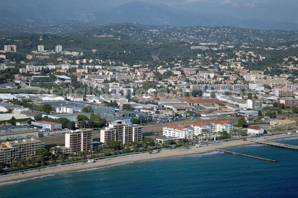 Cannes from the bird's eye view: Blick auf den Strand von Canne Las Bocca mit Gewerbegebiet und im Hintergrund den Alpen. Mit im Bild ist das erst vor kurzem fertiggestellte Hotel Le Royal Palm Residence am Boulevard De Midi im Stadtteil Las Bocca von Cannes. Kontakt Touristinfo: Office du Tourisme, BP 272, 06403 Cannes Cedex, Tel. +33(0)492 99842 2, Fax +33(0)492 99842 3, Email: tourisme@semec.com