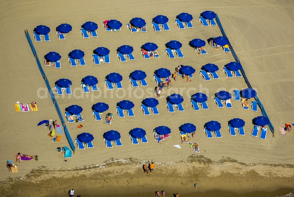 Canet-en-Roussillon from the bird's eye view: Beach lying places and umbrella on the sandy beach landscape of Canet-en-Roussillon on the Mediterranean coast in France. Use not permitted in personal rights affecting Zoom cutouts!