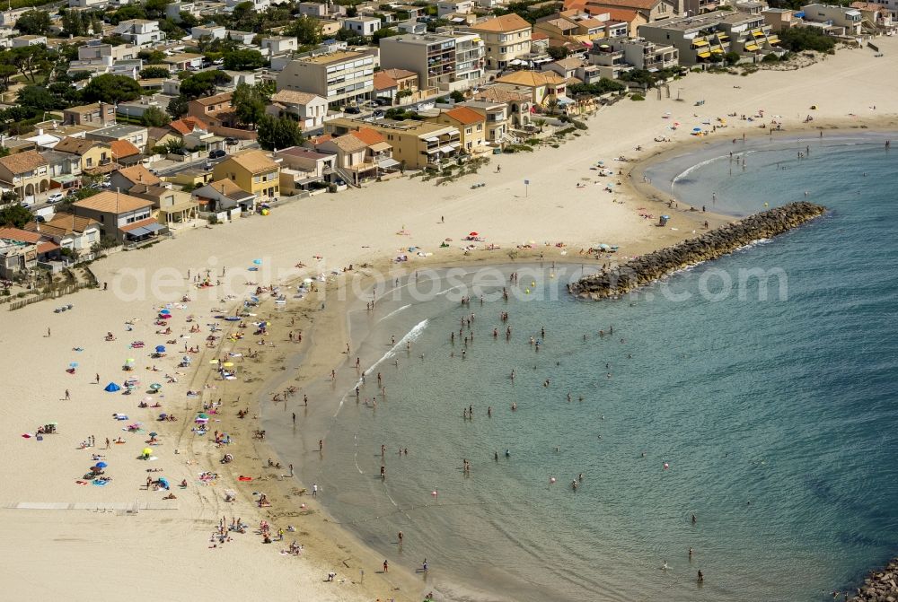 Mauguio from above - Beach lying places and umbrella on the sandy beach landscape of Mauguio on the Mediterranean coast of the province of Languedoc-Roussillon in France