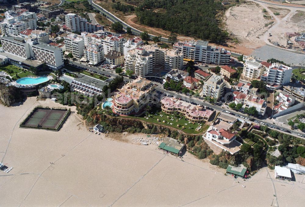 Aerial image Praia da Rocha - Blick auf das Strandufer von Praia da Rocha, ein beliebter Strand an der Algarve in Portugal. Er liegt zwischen Portimao und Alvor. Entstanden ist der ca. 1,5 km lange Küstenabschnitt durch die Meeresauswaschung von härteren Felsgestein aus dem sie umgebendem weicheren Material an der hier ca. 20-30 m hohen Steilküste. Oberhalb der Steilkante haben sich zahlreiche Hotels, Ferienwohnungen, Restaurants und Geschäfte den Standortvorteil gesichert.