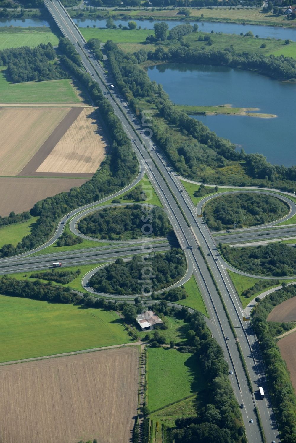 Minden from the bird's eye view: Intersection of the federal highways B61 and B65 on the shore of Lake Baltussee in the South of Minden in the state of North Rhine-Westphalia. The clover-leaf intersection is surrounded by trees and meadows and located on the western shore of the lake