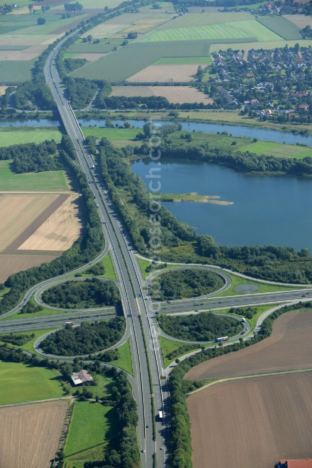 Aerial image Minden - Intersection of the federal highways B61 and B65 on the shore of Lake Baltussee in the South of Minden in the state of North Rhine-Westphalia. The clover-leaf intersection is surrounded by trees and meadows and located on the western shore of the lake