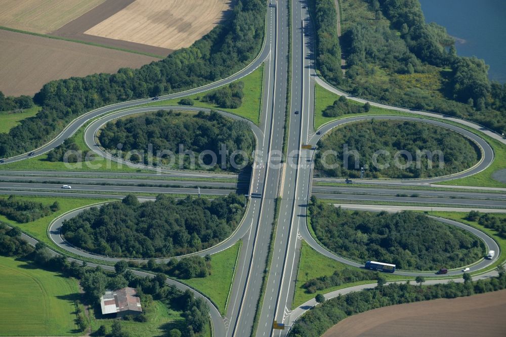 Aerial photograph Minden - Intersection of the federal highways B61 and B65 on the shore of Lake Baltussee in the South of Minden in the state of North Rhine-Westphalia. The clover-leaf intersection is surrounded by trees and meadows and located on the western shore of the lake