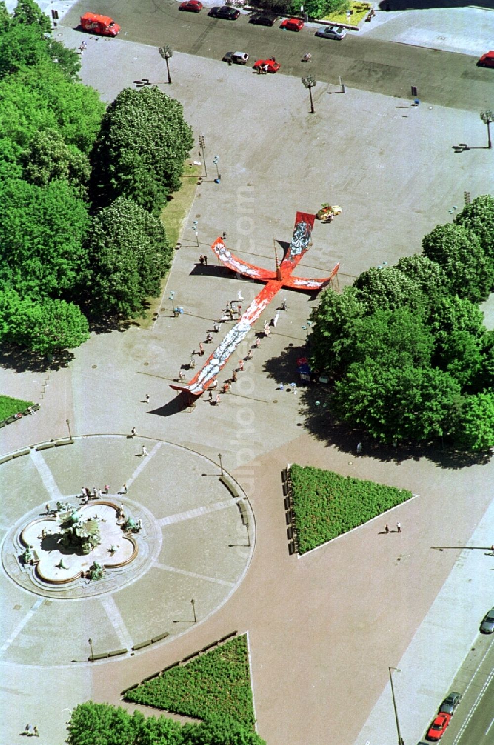 Aerial photograph Berlin - View of a street art project near the Neptune fountain on the Alexanderplatz in Berlin-Mitte. The photo shows a stylized cross with sculpture and exhibition panels in the environment