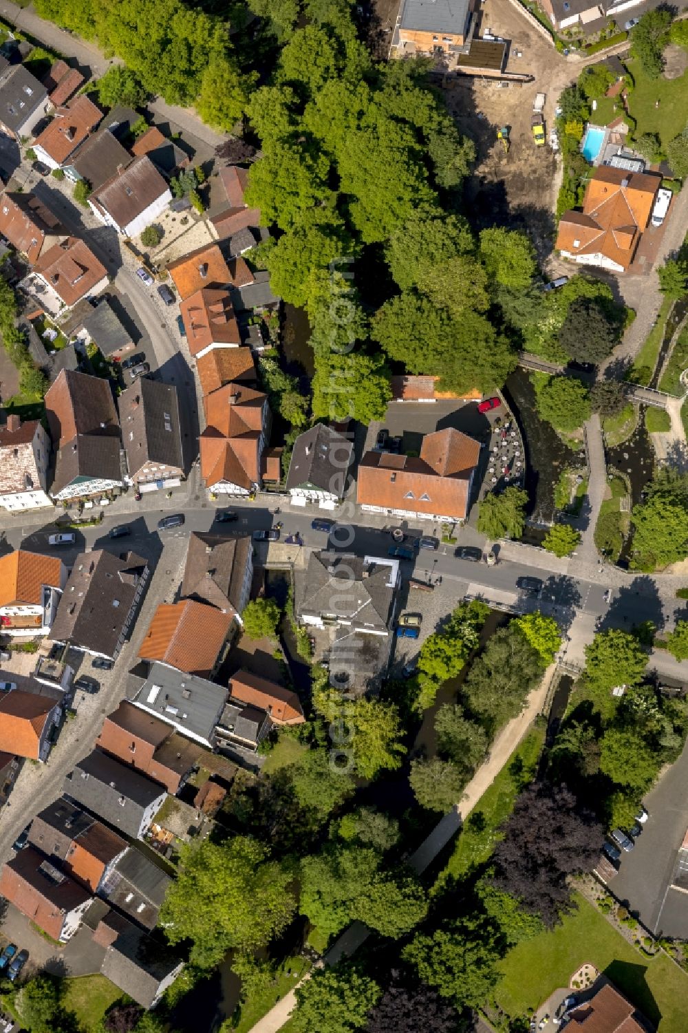 Aerial photograph Rietberg - View of the course of the Rathausstrasse through a residential area and then over a bridge over the Ems in Rietberg in the state North Rhine-Westphalia. It crosses the path An der Bleiche, which follows the course of the Ems