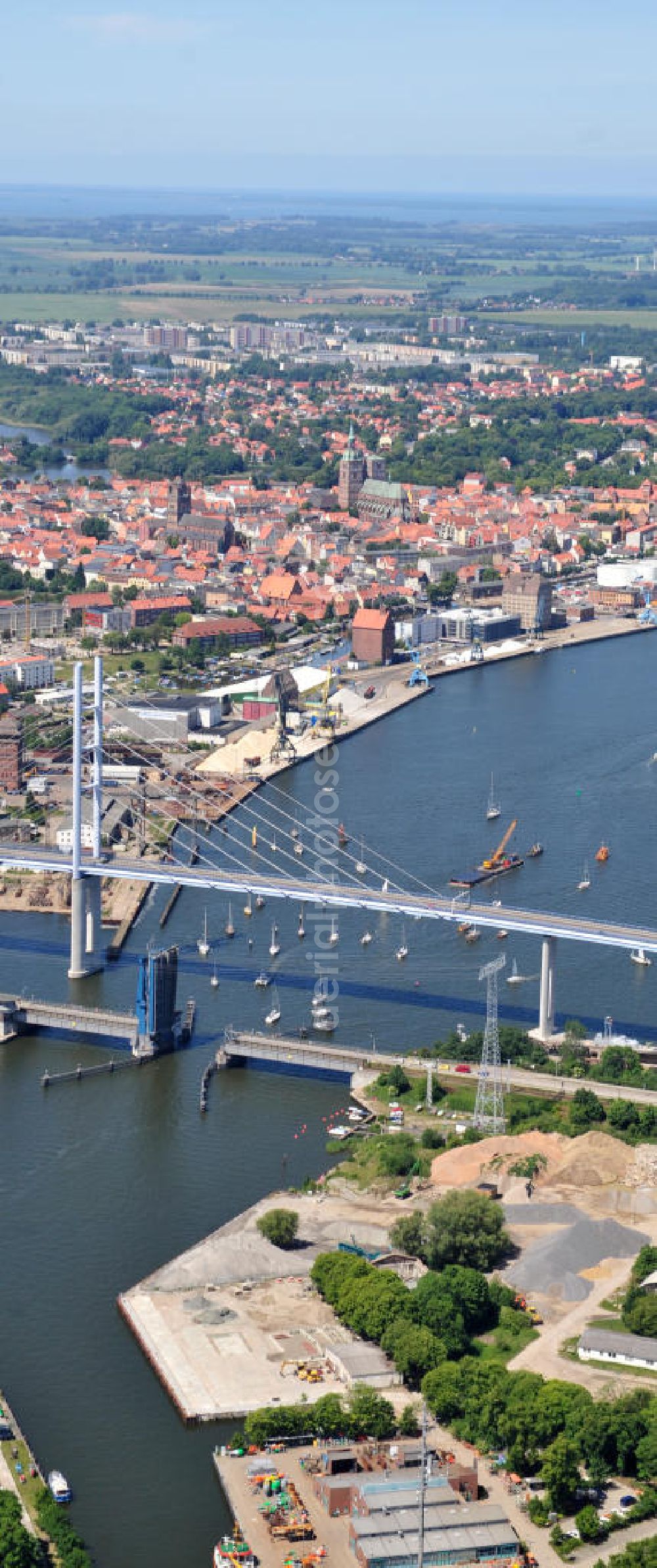 Hansestadt Stralsund from above - Blick auf die Strelasundquerung / Rügenbrücke mit Rügendamm vor der Stralsunder Altstadt. Im Auftrag des Bundesministeriums für Verkehr, Bau und Stadtentwicklung erfolgte die Planung und der Bau durch die Deutsche Einheit Fernstraßenplanungs- und -bau GmbH ( DEGES ). Die Bauausführung erfolgte durch die Arbeitsgemeinschaft 2.Strelasundquerung – MAX BÖGL-GMBH & Co.KG. Strelasund crossing / bridge to Rügen in Stralsund.