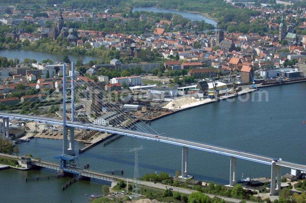 Stralsund from above - Mit dem Begriff Strelasundquerung werden die beiden Brückenverbindungen der Insel Rügen über den Strelasund zum vorpommerschen Festland bei Stralsund, die Rügenbrücke und der Rügendamm, sowie die regelmäßig betriebenen Fährverbindungen zwischen Stralsund und Altefähr sowie Stahlbrode und Glewitz bezeichnet. Der Rügendamm ist die erste feste Strelasundquerung, über den sowohl die alte Bundesstraße 96, als auch eine eingleisige Eisenbahnstrecke sowie ein kombinierter Fuß- und Radweg führen. Sie wurde 1936/1937 fertiggestellt. Rügenbrücke ist der Name der im Jahr 2007 fertiggestellten dreispurigen Hochbrücke ausschließlich für den Kraftfahrzeugverkehr zwischen der Ortschaft Altefähr auf Rügen und der Hanse- und Weltkulturerbestadt Stralsund im Zuge der als Ortsumgehung ausgebauten Bundesstraße 96. Beide Brücken werden parallel betrieben. (DEGES, MAX BÖGL)