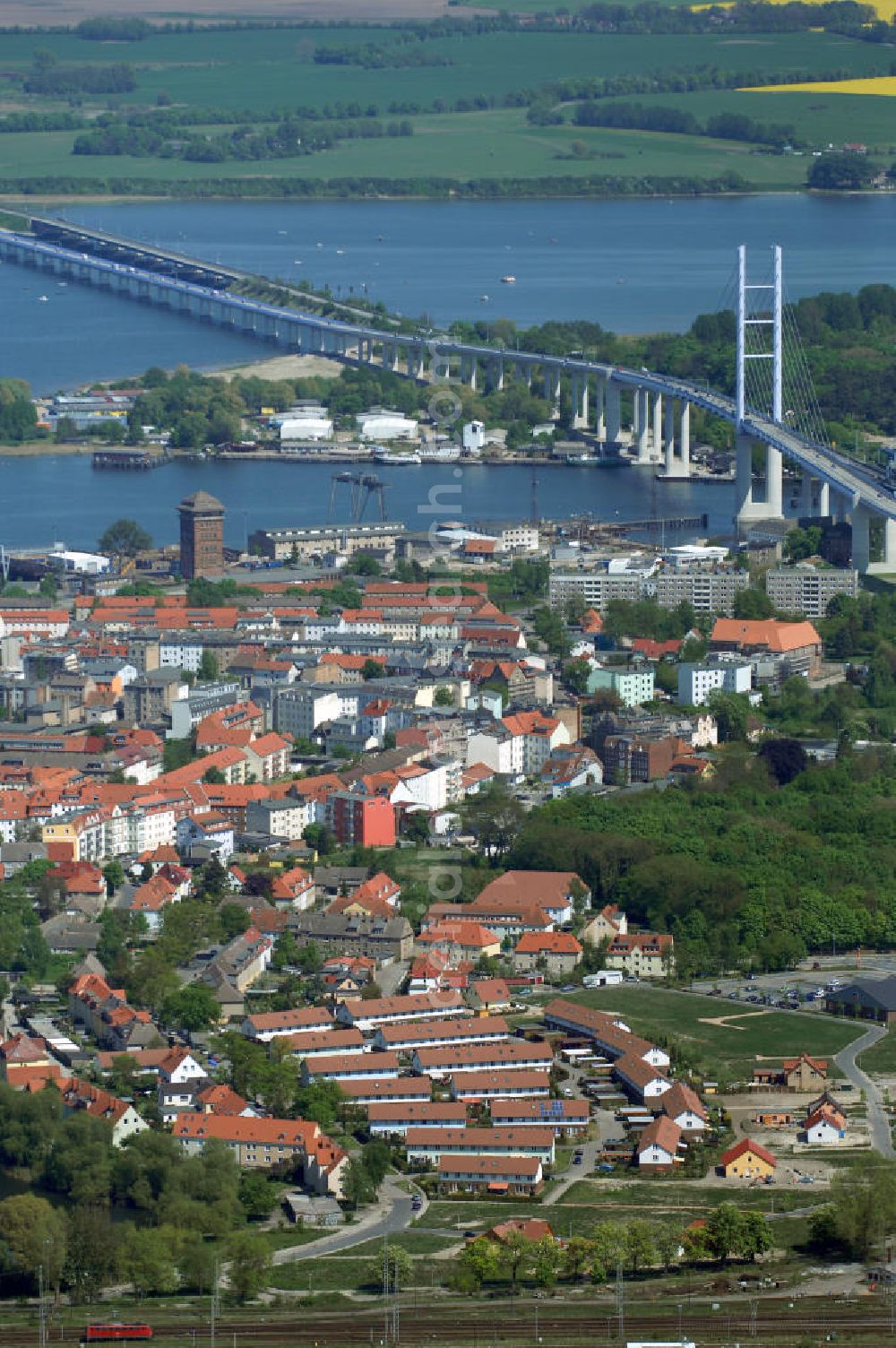 Stralsund from the bird's eye view: Mit dem Begriff Strelasundquerung werden die beiden Brückenverbindungen der Insel Rügen über den Strelasund zum vorpommerschen Festland bei Stralsund, die Rügenbrücke und der Rügendamm, sowie die regelmäßig betriebenen Fährverbindungen zwischen Stralsund und Altefähr sowie Stahlbrode und Glewitz bezeichnet. Der Rügendamm ist die erste feste Strelasundquerung, über den sowohl die alte Bundesstraße 96, als auch eine eingleisige Eisenbahnstrecke sowie ein kombinierter Fuß- und Radweg führen. Sie wurde 1936/1937 fertiggestellt. Rügenbrücke ist der Name der im Jahr 2007 fertiggestellten dreispurigen Hochbrücke ausschließlich für den Kraftfahrzeugverkehr zwischen der Ortschaft Altefähr auf Rügen und der Hanse- und Weltkulturerbestadt Stralsund im Zuge der als Ortsumgehung ausgebauten Bundesstraße 96. Beide Brücken werden parallel betrieben. (DEGES, MAX BÖGL)