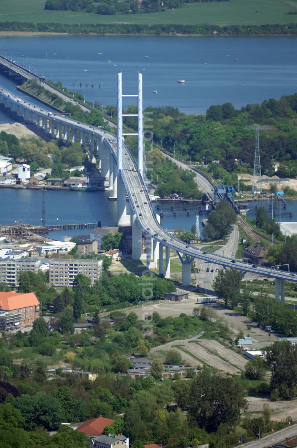 Aerial image Stralsund - Mit dem Begriff Strelasundquerung werden die beiden Brückenverbindungen der Insel Rügen über den Strelasund zum vorpommerschen Festland bei Stralsund, die Rügenbrücke und der Rügendamm, sowie die regelmäßig betriebenen Fährverbindungen zwischen Stralsund und Altefähr sowie Stahlbrode und Glewitz bezeichnet. Der Rügendamm ist die erste feste Strelasundquerung, über den sowohl die alte Bundesstraße 96, als auch eine eingleisige Eisenbahnstrecke sowie ein kombinierter Fuß- und Radweg führen. Sie wurde 1936/1937 fertiggestellt. Rügenbrücke ist der Name der im Jahr 2007 fertiggestellten dreispurigen Hochbrücke ausschließlich für den Kraftfahrzeugverkehr zwischen der Ortschaft Altefähr auf Rügen und der Hanse- und Weltkulturerbestadt Stralsund im Zuge der als Ortsumgehung ausgebauten Bundesstraße 96. Beide Brücken werden parallel betrieben. (DEGES, MAX BÖGL)