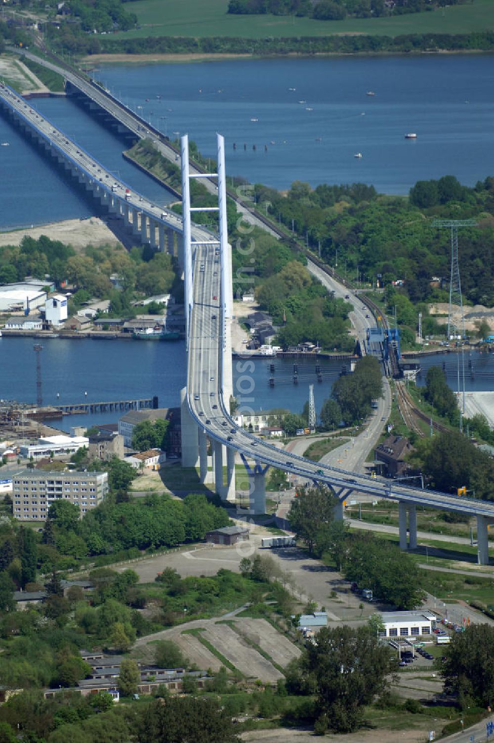 Aerial photograph Stralsund - Mit dem Begriff Strelasundquerung werden die beiden Brückenverbindungen der Insel Rügen über den Strelasund zum vorpommerschen Festland bei Stralsund, die Rügenbrücke und der Rügendamm, sowie die regelmäßig betriebenen Fährverbindungen zwischen Stralsund und Altefähr sowie Stahlbrode und Glewitz bezeichnet. Der Rügendamm ist die erste feste Strelasundquerung, über den sowohl die alte Bundesstraße 96, als auch eine eingleisige Eisenbahnstrecke sowie ein kombinierter Fuß- und Radweg führen. Sie wurde 1936/1937 fertiggestellt. Rügenbrücke ist der Name der im Jahr 2007 fertiggestellten dreispurigen Hochbrücke ausschließlich für den Kraftfahrzeugverkehr zwischen der Ortschaft Altefähr auf Rügen und der Hanse- und Weltkulturerbestadt Stralsund im Zuge der als Ortsumgehung ausgebauten Bundesstraße 96. Beide Brücken werden parallel betrieben. (DEGES, MAX BÖGL)