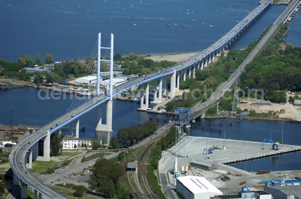 Stralsund from above - Mit dem Begriff Strelasundquerung werden die beiden Brückenverbindungen der Insel Rügen über den Strelasund zum vorpommerschen Festland bei Stralsund, die Rügenbrücke und der Rügendamm, sowie die regelmäßig betriebenen Fährverbindungen zwischen Stralsund und Altefähr sowie Stahlbrode und Glewitz bezeichnet. Der Rügendamm ist die erste feste Strelasundquerung, über den sowohl die alte Bundesstraße 96, als auch eine eingleisige Eisenbahnstrecke sowie ein kombinierter Fuß- und Radweg führen. Sie wurde 1936/1937 fertiggestellt. Rügenbrücke ist der Name der im Jahr 2007 fertiggestellten dreispurigen Hochbrücke ausschließlich für den Kraftfahrzeugverkehr zwischen der Ortschaft Altefähr auf Rügen und der Hanse- und Weltkulturerbestadt Stralsund im Zuge der als Ortsumgehung ausgebauten Bundesstraße 96. Beide Brücken werden parallel betrieben. (DEGES, MAX BÖGL)