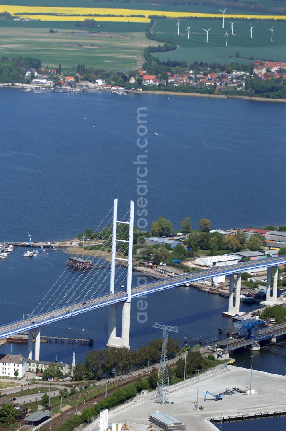 Aerial image Stralsund - Mit dem Begriff Strelasundquerung werden die beiden Brückenverbindungen der Insel Rügen über den Strelasund zum vorpommerschen Festland bei Stralsund, die Rügenbrücke und der Rügendamm, sowie die regelmäßig betriebenen Fährverbindungen zwischen Stralsund und Altefähr sowie Stahlbrode und Glewitz bezeichnet. Der Rügendamm ist die erste feste Strelasundquerung, über den sowohl die alte Bundesstraße 96, als auch eine eingleisige Eisenbahnstrecke sowie ein kombinierter Fuß- und Radweg führen. Sie wurde 1936/1937 fertiggestellt. Rügenbrücke ist der Name der im Jahr 2007 fertiggestellten dreispurigen Hochbrücke ausschließlich für den Kraftfahrzeugverkehr zwischen der Ortschaft Altefähr auf Rügen und der Hanse- und Weltkulturerbestadt Stralsund im Zuge der als Ortsumgehung ausgebauten Bundesstraße 96. Beide Brücken werden parallel betrieben. (DEGES, MAX BÖGL)