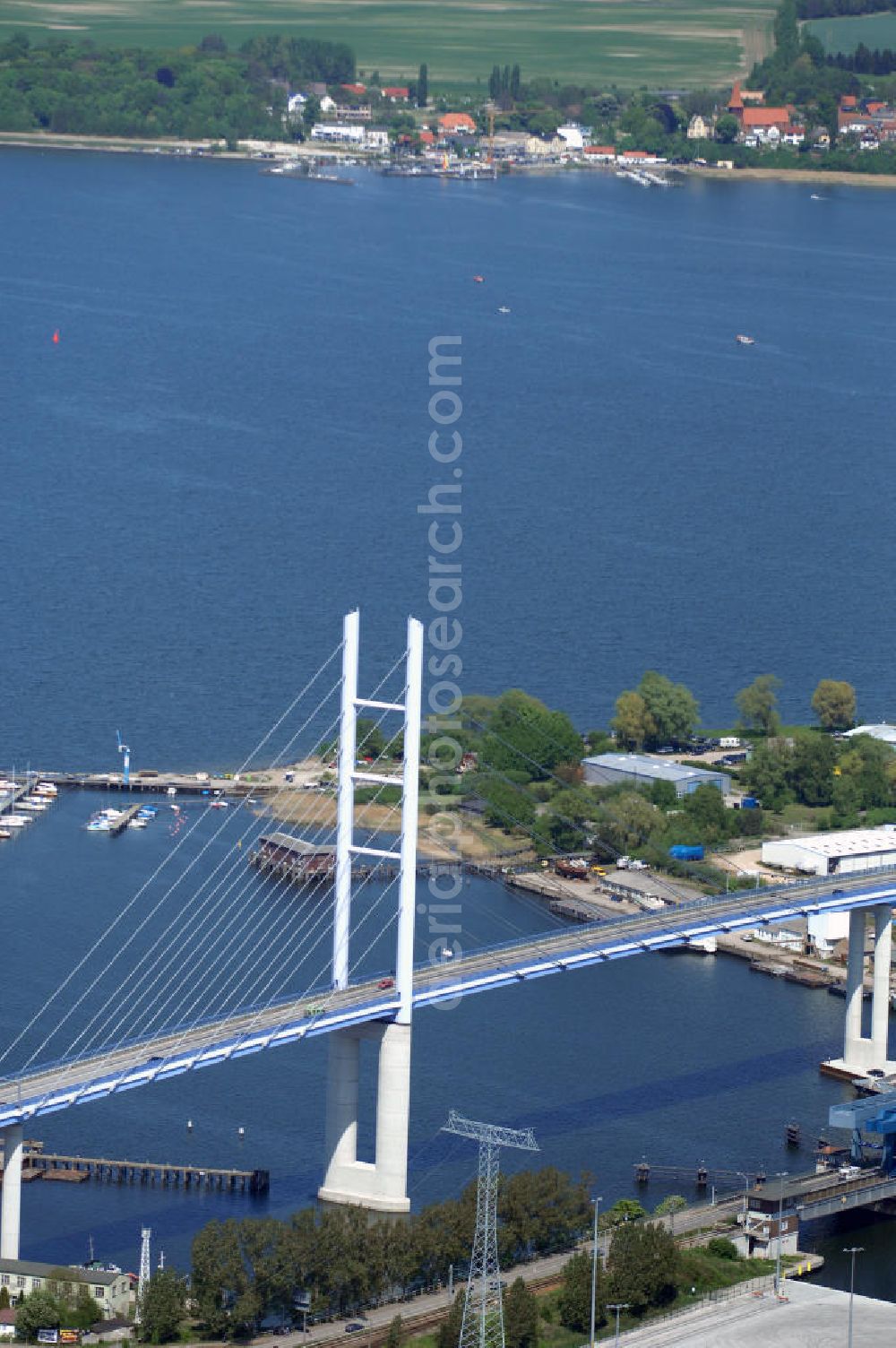 Aerial photograph Stralsund - Mit dem Begriff Strelasundquerung werden die beiden Brückenverbindungen der Insel Rügen über den Strelasund zum vorpommerschen Festland bei Stralsund, die Rügenbrücke und der Rügendamm, sowie die regelmäßig betriebenen Fährverbindungen zwischen Stralsund und Altefähr sowie Stahlbrode und Glewitz bezeichnet. Der Rügendamm ist die erste feste Strelasundquerung, über den sowohl die alte Bundesstraße 96, als auch eine eingleisige Eisenbahnstrecke sowie ein kombinierter Fuß- und Radweg führen. Sie wurde 1936/1937 fertiggestellt. Rügenbrücke ist der Name der im Jahr 2007 fertiggestellten dreispurigen Hochbrücke ausschließlich für den Kraftfahrzeugverkehr zwischen der Ortschaft Altefähr auf Rügen und der Hanse- und Weltkulturerbestadt Stralsund im Zuge der als Ortsumgehung ausgebauten Bundesstraße 96. Beide Brücken werden parallel betrieben. (DEGES, MAX BÖGL)