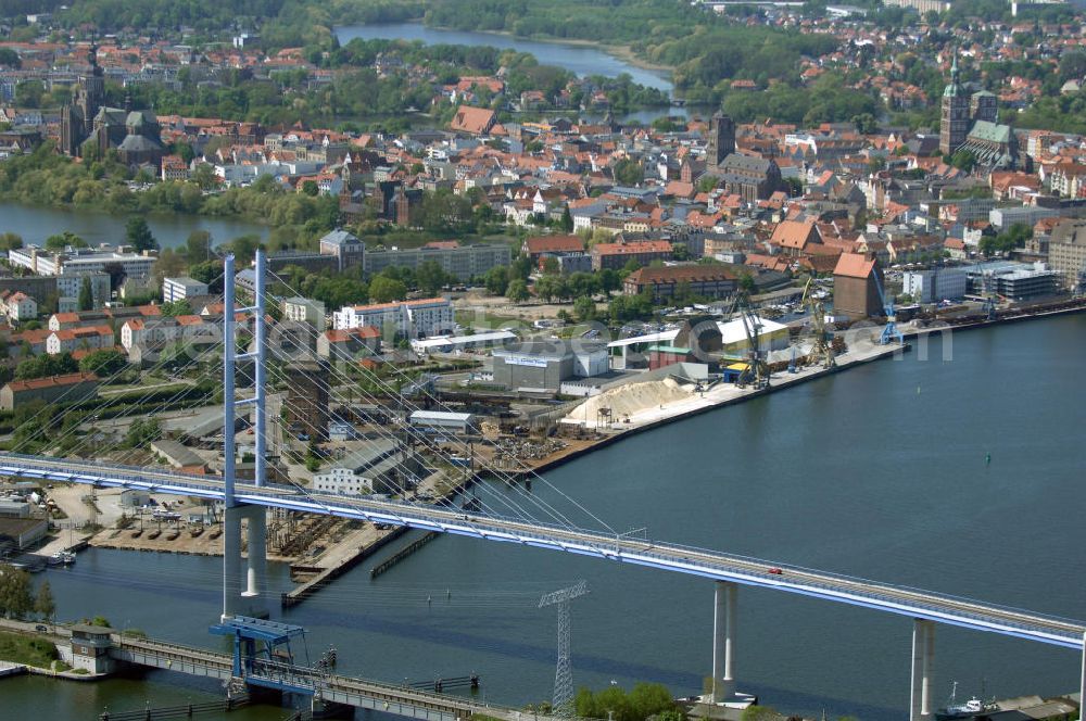 Stralsund from above - Mit dem Begriff Strelasundquerung werden die beiden Brückenverbindungen der Insel Rügen über den Strelasund zum vorpommerschen Festland bei Stralsund, die Rügenbrücke und der Rügendamm, sowie die regelmäßig betriebenen Fährverbindungen zwischen Stralsund und Altefähr sowie Stahlbrode und Glewitz bezeichnet. Der Rügendamm ist die erste feste Strelasundquerung, über den sowohl die alte Bundesstraße 96, als auch eine eingleisige Eisenbahnstrecke sowie ein kombinierter Fuß- und Radweg führen. Sie wurde 1936/1937 fertiggestellt. Rügenbrücke ist der Name der im Jahr 2007 fertiggestellten dreispurigen Hochbrücke ausschließlich für den Kraftfahrzeugverkehr zwischen der Ortschaft Altefähr auf Rügen und der Hanse- und Weltkulturerbestadt Stralsund im Zuge der als Ortsumgehung ausgebauten Bundesstraße 96. Beide Brücken werden parallel betrieben. (DEGES, MAX BÖGL)