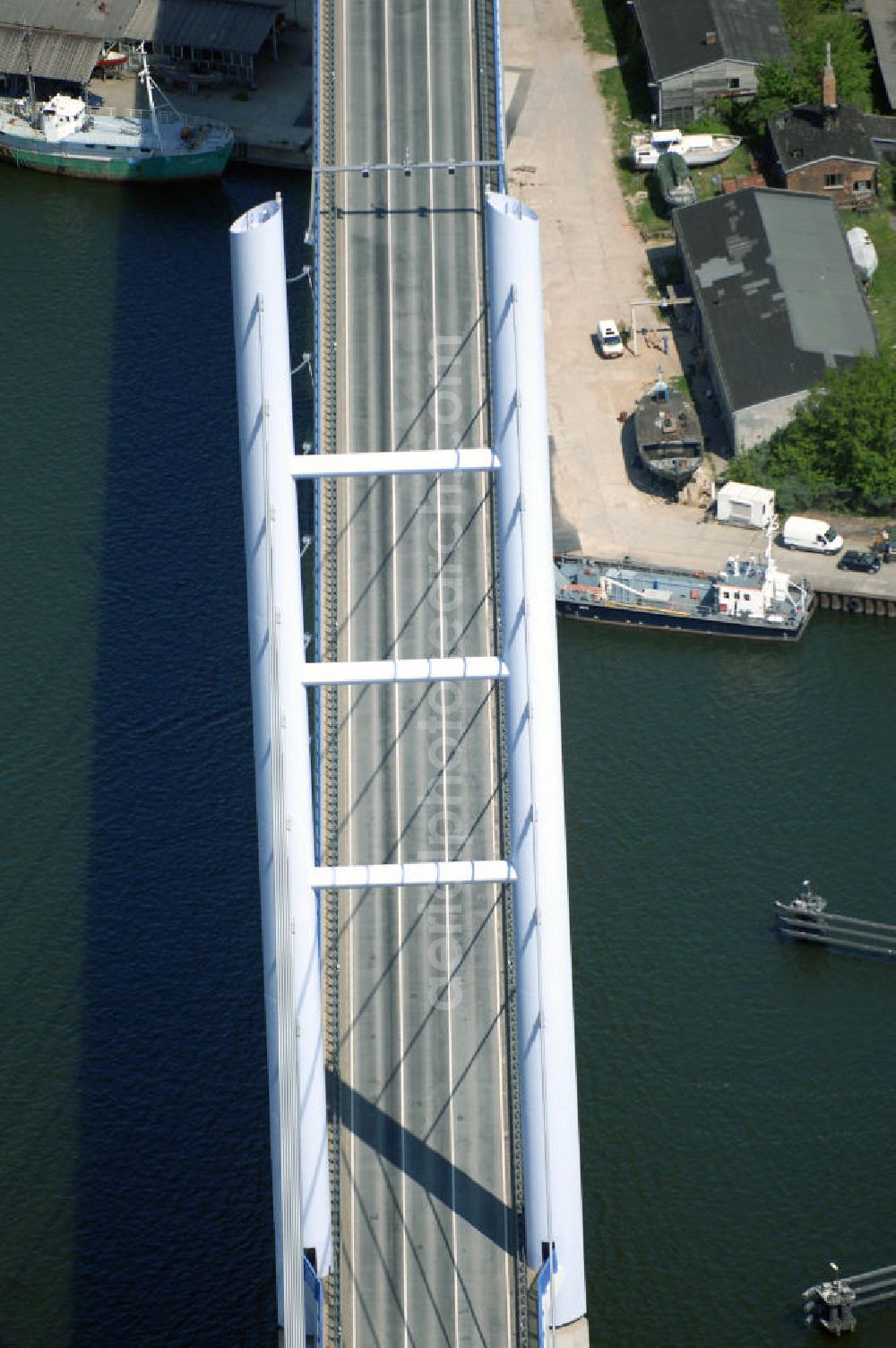 Aerial photograph Stralsund - Mit dem Begriff Strelasundquerung werden die beiden Brückenverbindungen der Insel Rügen über den Strelasund zum vorpommerschen Festland bei Stralsund, die Rügenbrücke und der Rügendamm, sowie die regelmäßig betriebenen Fährverbindungen zwischen Stralsund und Altefähr sowie Stahlbrode und Glewitz bezeichnet. Der Rügendamm ist die erste feste Strelasundquerung, über den sowohl die alte Bundesstraße 96, als auch eine eingleisige Eisenbahnstrecke sowie ein kombinierter Fuß- und Radweg führen. Sie wurde 1936/1937 fertiggestellt. Rügenbrücke ist der Name der im Jahr 2007 fertiggestellten dreispurigen Hochbrücke ausschließlich für den Kraftfahrzeugverkehr zwischen der Ortschaft Altefähr auf Rügen und der Hanse- und Weltkulturerbestadt Stralsund im Zuge der als Ortsumgehung ausgebauten Bundesstraße 96. Beide Brücken werden parallel betrieben. (DEGES, MAX BÖGL)