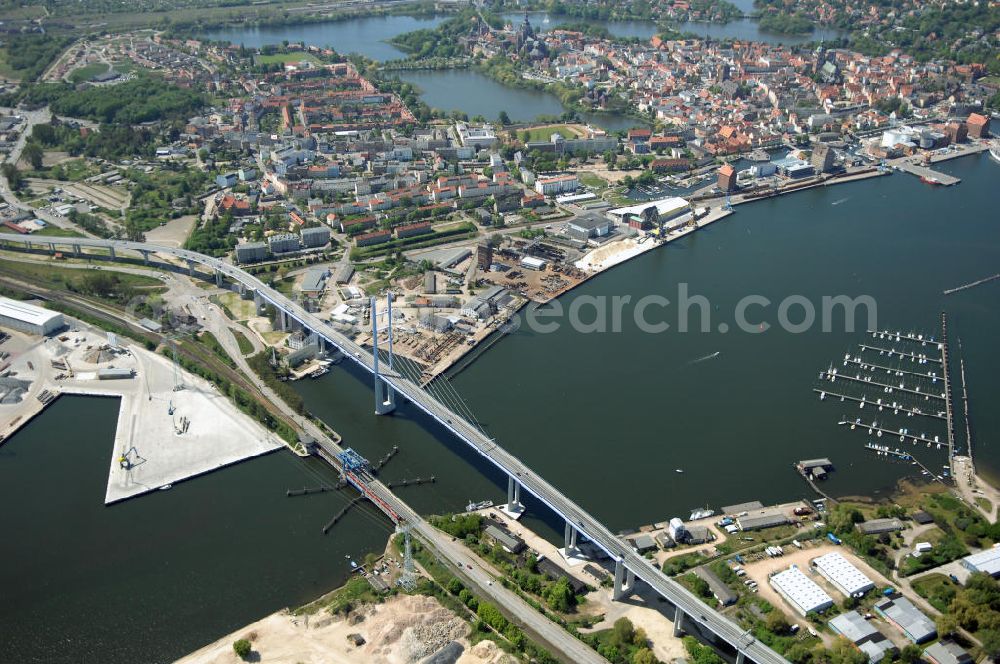 Aerial photograph Stralsund - Mit dem Begriff Strelasundquerung werden die beiden Brückenverbindungen der Insel Rügen über den Strelasund zum vorpommerschen Festland bei Stralsund, die Rügenbrücke und der Rügendamm, sowie die regelmäßig betriebenen Fährverbindungen zwischen Stralsund und Altefähr sowie Stahlbrode und Glewitz bezeichnet. Der Rügendamm ist die erste feste Strelasundquerung, über den sowohl die alte Bundesstraße 96, als auch eine eingleisige Eisenbahnstrecke sowie ein kombinierter Fuß- und Radweg führen. Sie wurde 1936/1937 fertiggestellt. Rügenbrücke ist der Name der im Jahr 2007 fertiggestellten dreispurigen Hochbrücke ausschließlich für den Kraftfahrzeugverkehr zwischen der Ortschaft Altefähr auf Rügen und der Hanse- und Weltkulturerbestadt Stralsund im Zuge der als Ortsumgehung ausgebauten Bundesstraße 96. Beide Brücken werden parallel betrieben. (DEGES, MAX BÖGL)