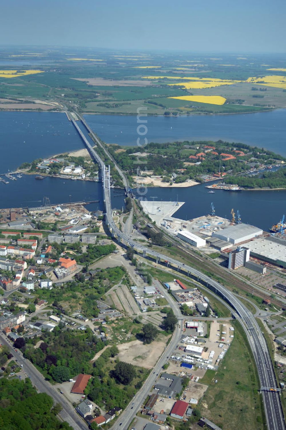 Aerial image Stralsund - Mit dem Begriff Strelasundquerung werden die beiden Brückenverbindungen der Insel Rügen über den Strelasund zum vorpommerschen Festland bei Stralsund, die Rügenbrücke und der Rügendamm, sowie die regelmäßig betriebenen Fährverbindungen zwischen Stralsund und Altefähr sowie Stahlbrode und Glewitz bezeichnet. Der Rügendamm ist die erste feste Strelasundquerung, über den sowohl die alte Bundesstraße 96, als auch eine eingleisige Eisenbahnstrecke sowie ein kombinierter Fuß- und Radweg führen. Sie wurde 1936/1937 fertiggestellt. Rügenbrücke ist der Name der im Jahr 2007 fertiggestellten dreispurigen Hochbrücke ausschließlich für den Kraftfahrzeugverkehr zwischen der Ortschaft Altefähr auf Rügen und der Hanse- und Weltkulturerbestadt Stralsund im Zuge der als Ortsumgehung ausgebauten Bundesstraße 96. Beide Brücken werden parallel betrieben. (DEGES, MAX BÖGL)