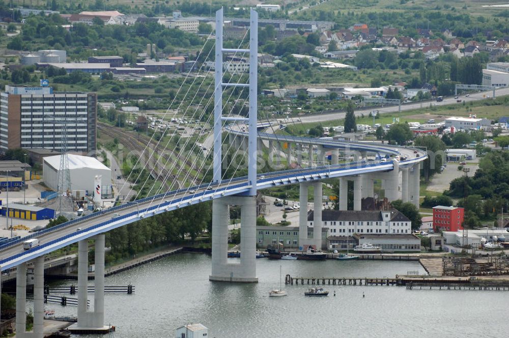 Stralsund from above - Mit dem Begriff Strelasundquerung werden die beiden Brückenverbindungen der Insel Rügen über den Strelasund zum vorpommerschen Festland bei Stralsund, die Rügenbrücke und der Rügendamm , sowie die regelmäßig betriebenen Fährverbindungen zwischen Stralsund und Altefähr sowie Stahlbrode und Glewitz bezeichnet. Der Rügendamm ist die erste feste Strelasundquerung, über den sowohl die alte Bundesstraße 96, als auch eine eingleisige Eisenbahnstrecke sowie ein kombinierter Fuß- und Radweg führen. Sie wurde 1936/1937 fertiggestellt. Rügenbrücke ist der Name der im Jahr 2007 fertiggestellten dreispurigen Hochbrücke ausschließlich für den Kraftfahrzeugverkehr zwischen der Ortschaft Altefähr auf Rügen und der Hanse- und Weltkulturerbestadt Stralsund im Zuge der als Ortsumgehung ausgebauten Bundesstraße 96. Beide Brücken werden parallel betrieben. (DEGES, MAX BÖGL)