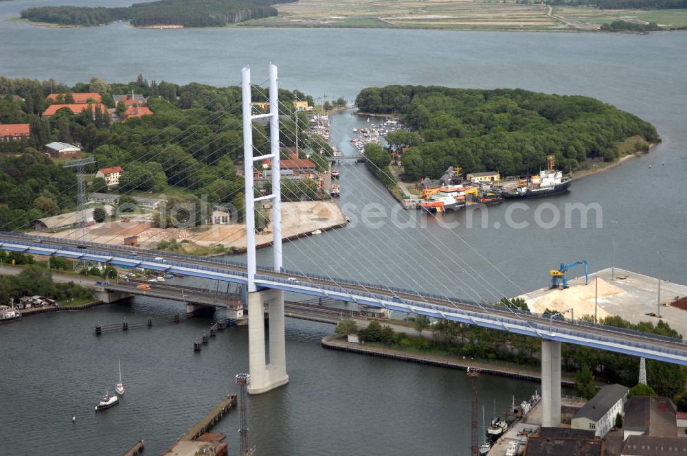 Stralsund from the bird's eye view: Mit dem Begriff Strelasundquerung werden die beiden Brückenverbindungen der Insel Rügen über den Strelasund zum vorpommerschen Festland bei Stralsund, die Rügenbrücke und der Rügendamm , sowie die regelmäßig betriebenen Fährverbindungen zwischen Stralsund und Altefähr sowie Stahlbrode und Glewitz bezeichnet. Der Rügendamm ist die erste feste Strelasundquerung, über den sowohl die alte Bundesstraße 96, als auch eine eingleisige Eisenbahnstrecke sowie ein kombinierter Fuß- und Radweg führen. Sie wurde 1936/1937 fertiggestellt. Rügenbrücke ist der Name der im Jahr 2007 fertiggestellten dreispurigen Hochbrücke ausschließlich für den Kraftfahrzeugverkehr zwischen der Ortschaft Altefähr auf Rügen und der Hanse- und Weltkulturerbestadt Stralsund im Zuge der als Ortsumgehung ausgebauten Bundesstraße 96. Beide Brücken werden parallel betrieben. (DEGES, MAX BÖGL)