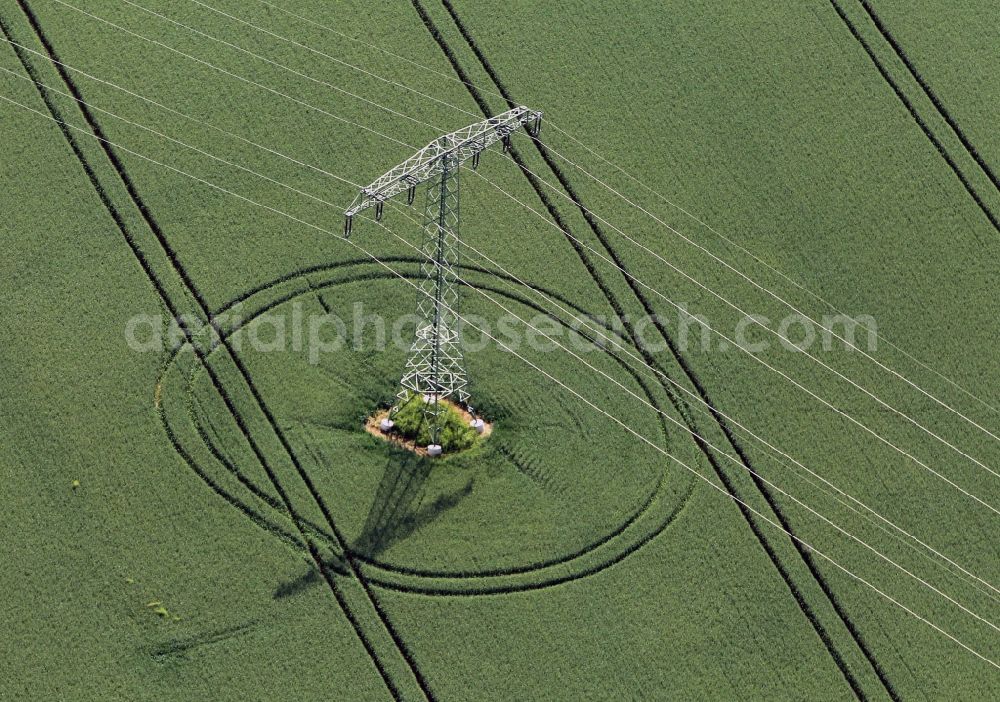 Erfurt from above - View on a pylon of a high voltage line standing in a green field near Erfurt in the state of Thuringia. The lane for the tractor are shown in the field